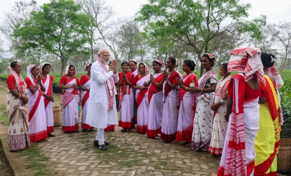 ਪ੍ਰਧਾਨ ਮੰਤਰੀ ਨਰਿੰਦਰ ਮੋਦੀ ਅਸਾਮ ਦੇ ਚਾਹ ਬਾਗ ਵਿੱਚ ਚਾਹ ਮਜ਼ਦੂਰਾਂ ਨਾਲ ਗੱਲਬਾਤ ਕਰਦੇ ਹੋਏ।